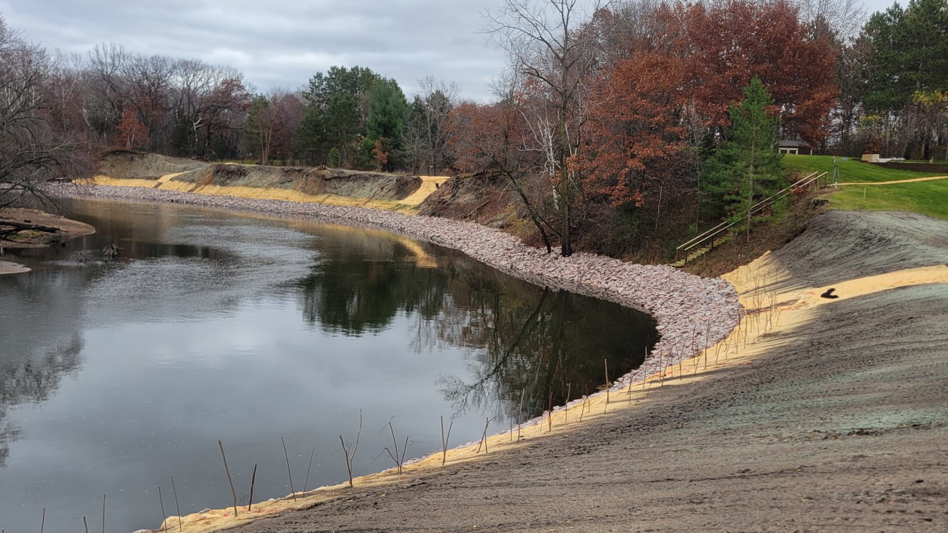 After construction, view of restored riverbanks with fall foliage.